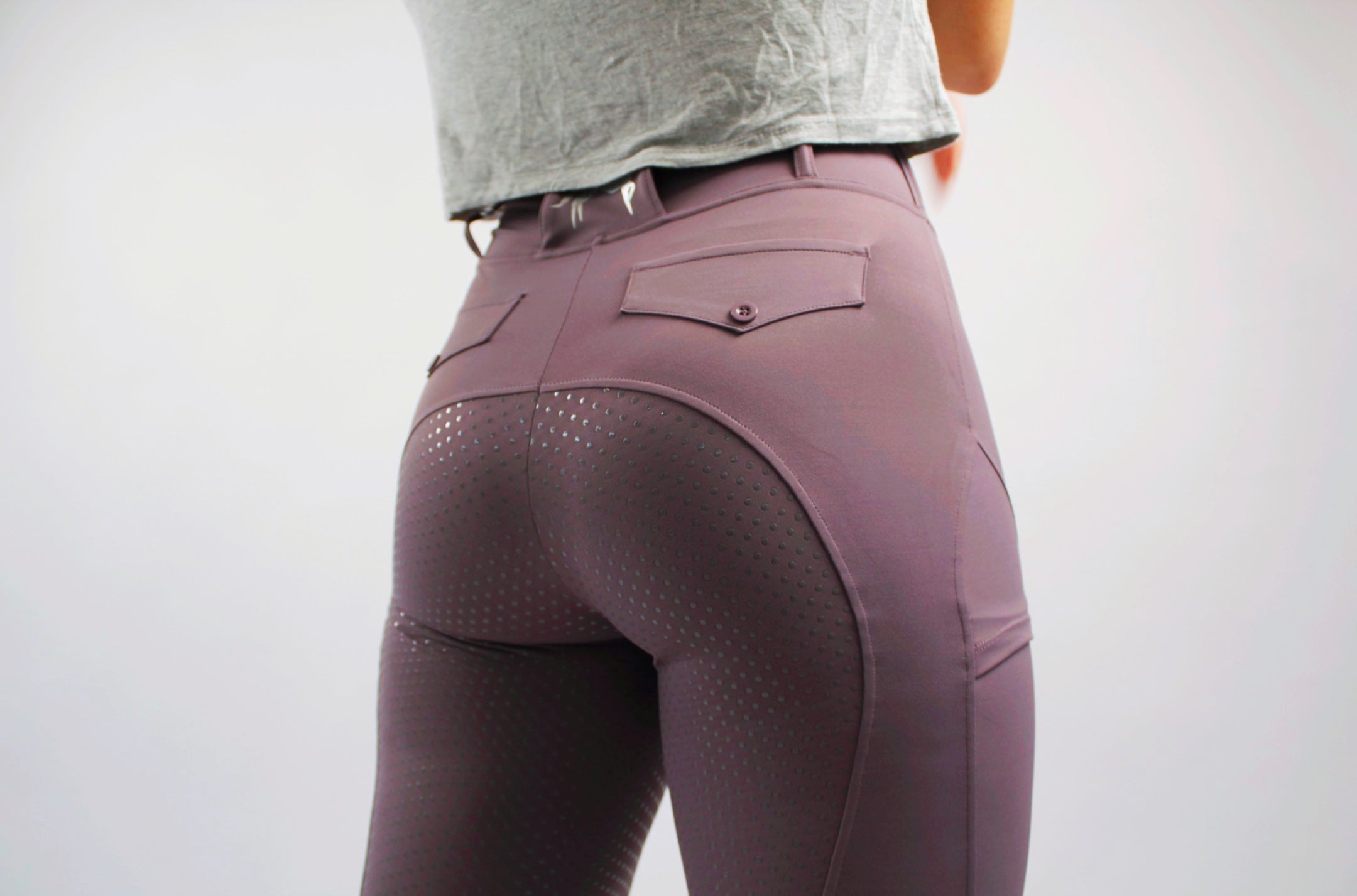 back view of plum fusion tights, highlighting silicone seat and back pockets