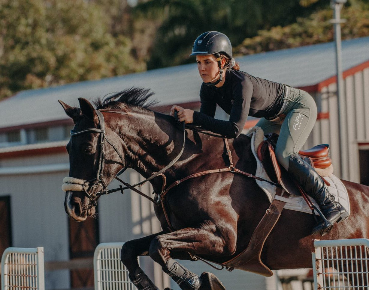 Showjumping picture of girl and her horse in Motion Base Layer Black and Fusion Tights Sage