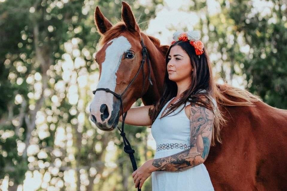 beautiful photo of dressed up tattoed girl holding her horse