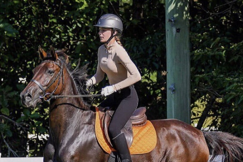 young rider approaching a jump